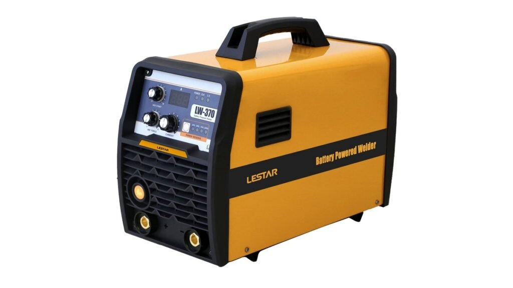 Portable battery powered welder on garage floor with helmet and gloves