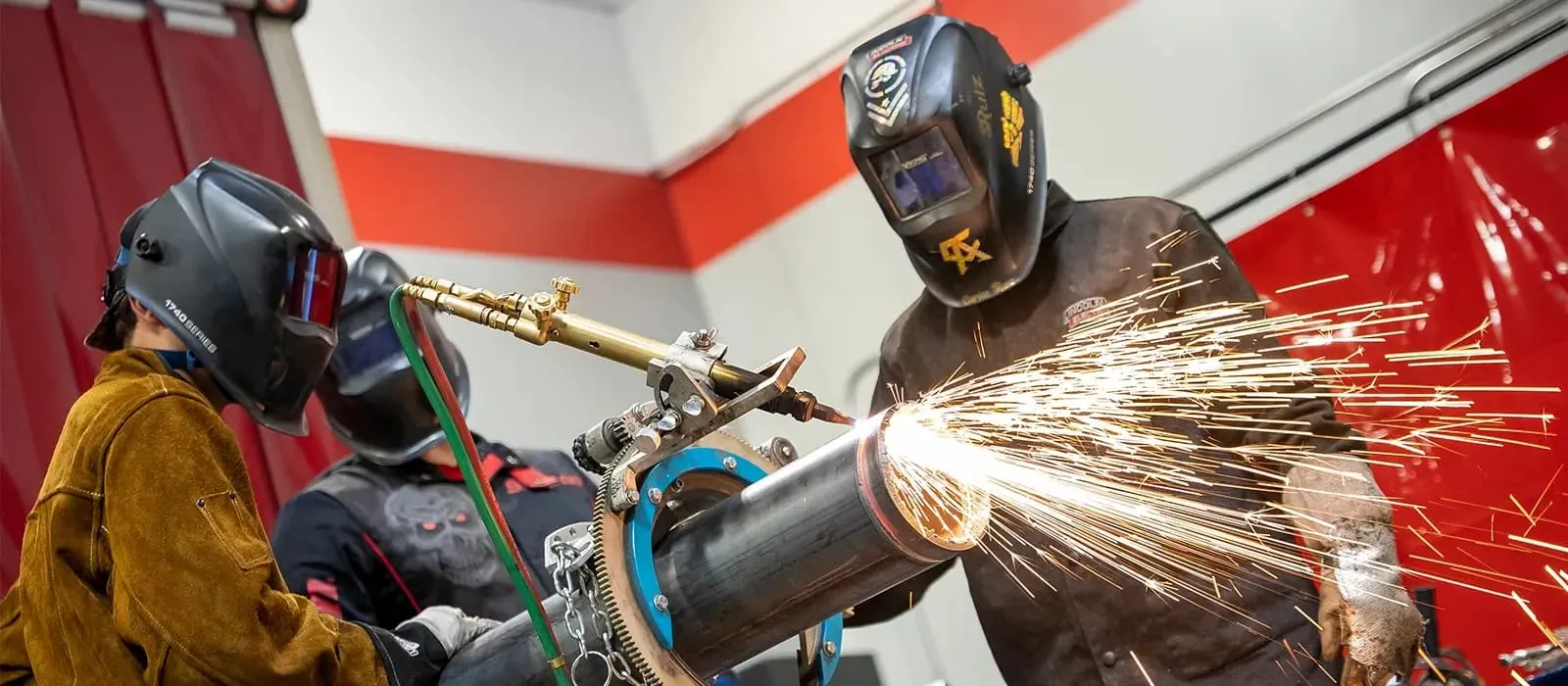 Two welding machines side by side on a workshop floor comparing duty cycle ratings.